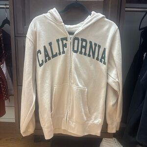 Tan zip up with green california letters
